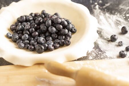 a fresh blueberry pie in the process of being baked.の写真素材