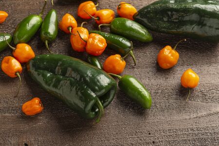fresh poblano, jalapeno and habanero peppers on a wood background, overheadの写真素材