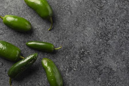fresh jalapeno peppers on a dark concrete backgroundの写真素材