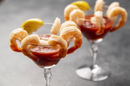 shrimp cocktail appetizers in crystal martini glasses with lemon wedgesの写真素材