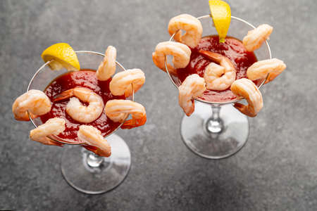 shrimp cocktail appetizers in crystal martini glasses with lemon wedgesの写真素材