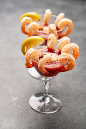 shrimp cocktail appetizers in crystal martini glasses with lemon wedgesの写真素材