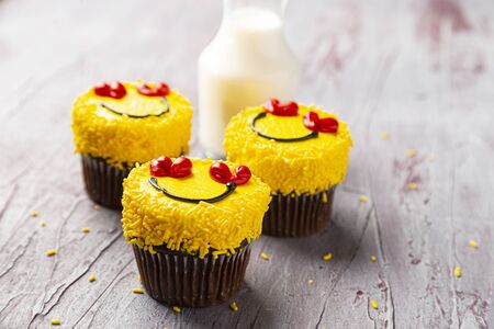 Three smiling cupcakes horizontal with milkの写真素材