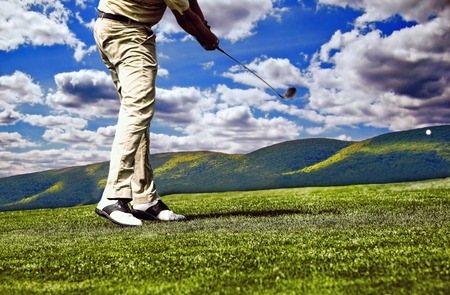 golfer hitting shot on courseの写真素材