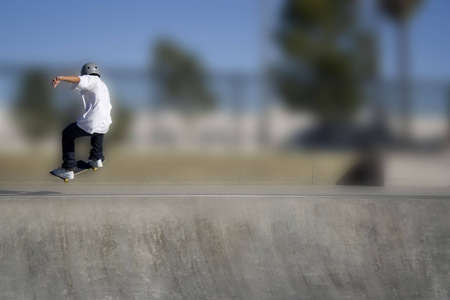 skateboarder riding over lip of ramp at a skate parkの写真素材