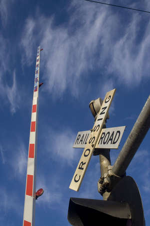 view of railroad crossbar stretching into the blue skyの写真素材