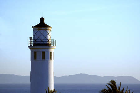 lighthouse windows overlooking the ocean and mountains in the distanceの写真素材
