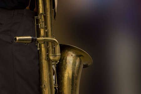 bass sax resting against the player's leg with a blurred backgroundの写真素材
