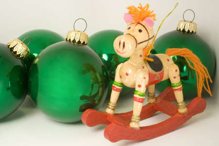 wooden rocking horse ornament and green baubles with brass loopsの写真素材