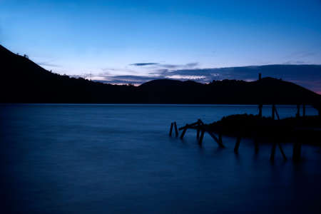 Wharf on a dark blue lake early in the morning during sunrise with nobody around.の写真素材