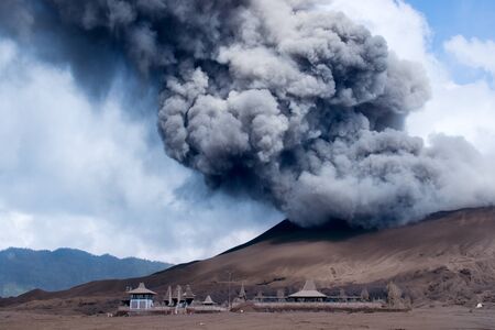 Grey smoke coming out of an active volcano filling the sky at the Tengger Semeru National Park in East Java, Indonesia.の写真素材