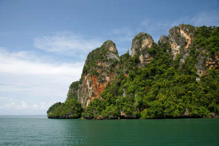 Island filled with green trees in the middle of the sea in the afternoon at Krabi, Thailand.の写真素材