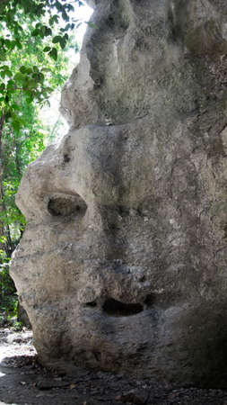 Grey natural rock at daytime that looks like a face with eye mouth and nose in Flores, Indonesia.の写真素材