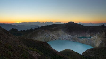 High panoramic view of the green turquoise colored lake in the Kelimutu volcano during the morning at sunrise with nobody around, Indonesia.の写真素材