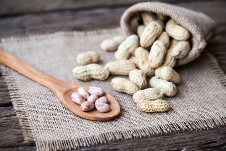 Peanut in sacks on the wooden backgroundの写真素材