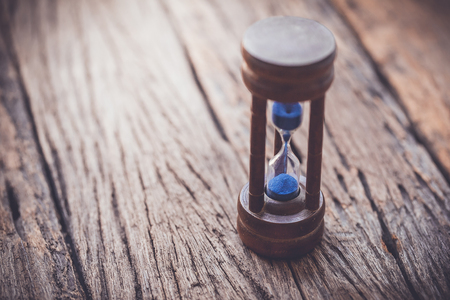 hourglass on wooden background,vintage color tone