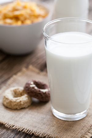 milk, cookies and bowl of cereal on wooden backgroundの写真素材