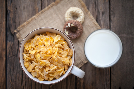milk, cookies and bowl of cereal on wooden backgroundの写真素材