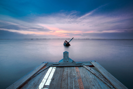 Shipwreck of fish boat at sunset in Thailand.の写真素材