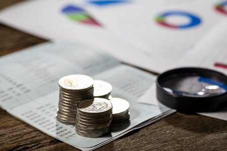 coins on bank account passbook and business chart Magnifyingの写真素材