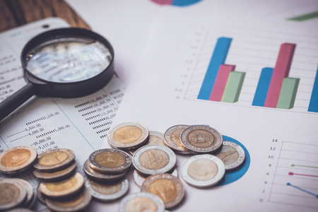 coins on bank account passbook and business chart Magnifyingの写真素材