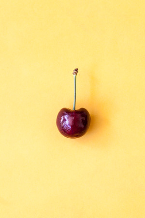 red cherry on yellow background