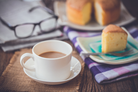 cup of coffee and cake on wooden tableの写真素材
