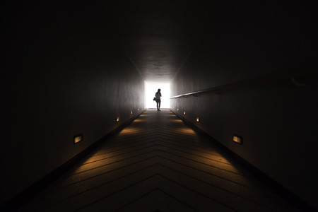 silhouette of a girl at the end of the tunnel
