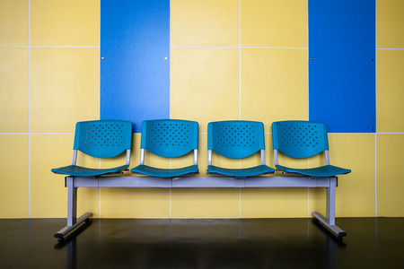 Blue chairs on yellow wall backgroundの写真素材