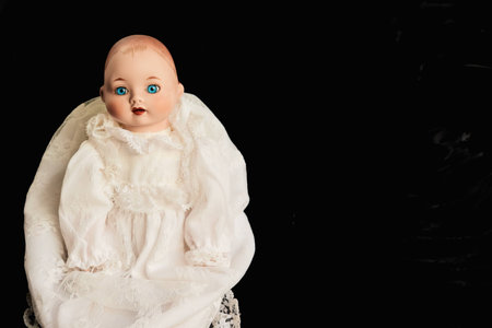 Closeup of old porcelain child doll with blue eyes on black backgroundの写真素材