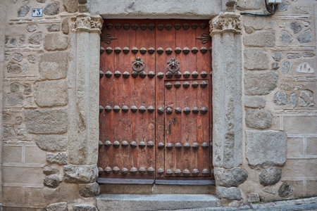Old dark brown wooden door with two knockers in Toledo, Spainの写真素材