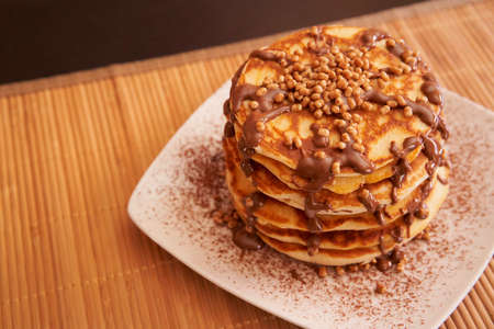 Delicious plate of pancakes with peanut syrup, cocoa and toppings