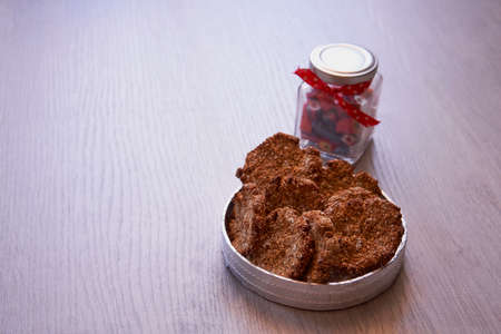 Delicious banana cookies with oatmeal and cinnamon next to jar with candies
