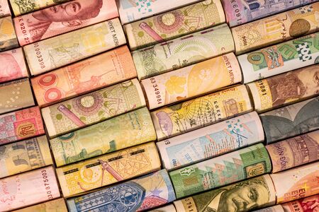 Different colourful banknotes from various countries on rolls to be used for illustrating subjects as business, banking, media, etc.の写真素材