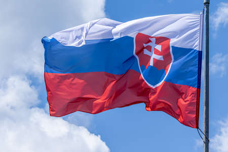 Slovak national flag waving on blue sky background. Slovak Republic, SKの写真素材