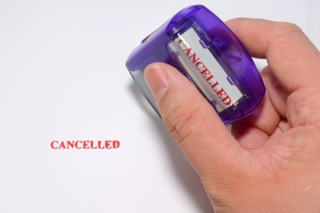 The Red Cancelled is Stamping on White Paper, isolated cancelled stamp in red color holding by right handの写真素材