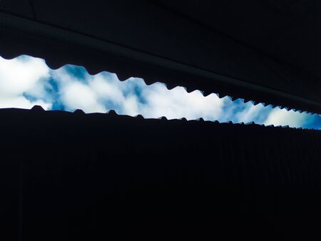 Looking up roof with blue sky and clouds
