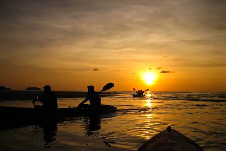 Silhouette of sea kayaking at sunsetの写真素材