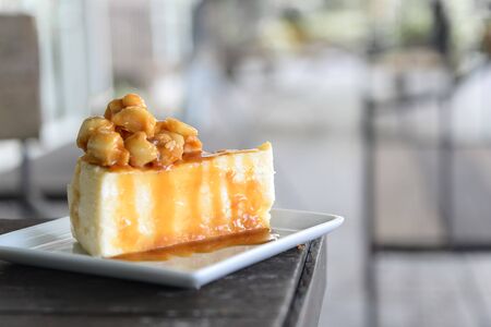 A piece of caramel cake with macadamia toppingの写真素材