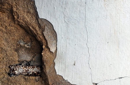 rusty cylinder steel in broken old dirty concrete wall for backgroundの写真素材