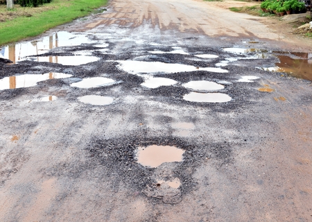 many hole on asphalt road in countryside in rainy seasonの写真素材