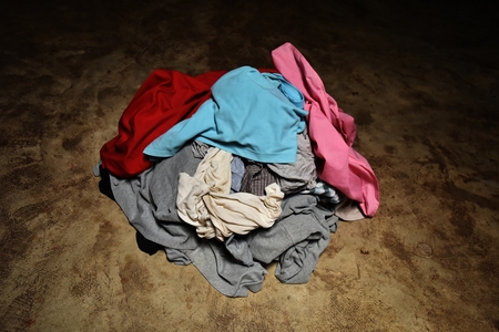 pile of dirty clothes on cement groundの写真素材