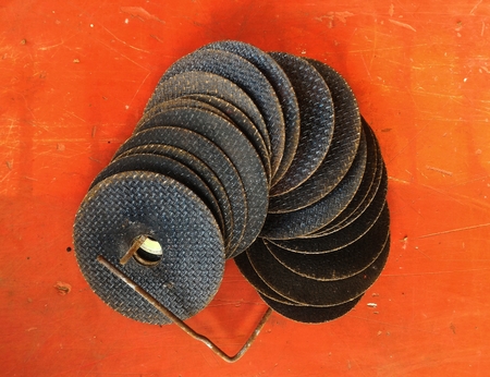 many old grinding disc after used on old orange backgroundの写真素材