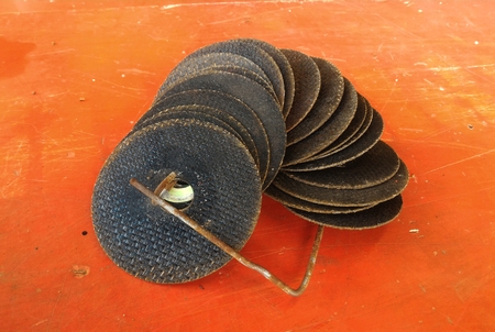 many old grinding disc after used on old orange backgroundの写真素材