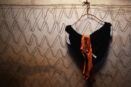 brown bra and black underwear on hanger and dirty cement wall for backgroundの写真素材