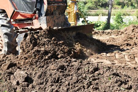 tractor push clot soil after pour from truck