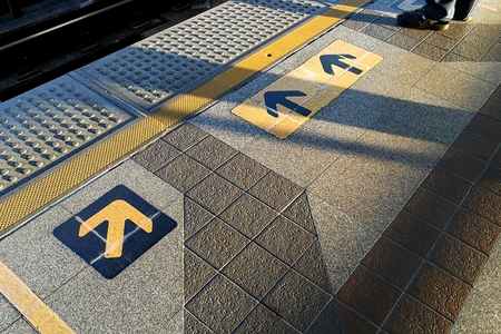yellow arrow on ground in morning time in train stationの写真素材