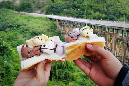 ice cream on bread in hand and bridge road between travel in holidayの写真素材