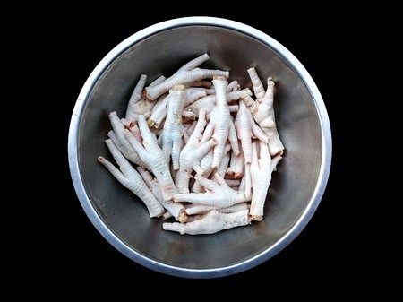 many chicken feet in steel bowl on black  backgroundの写真素材