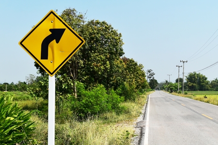 old and dirty traffic signs beside asphalt road in countrysideの写真素材